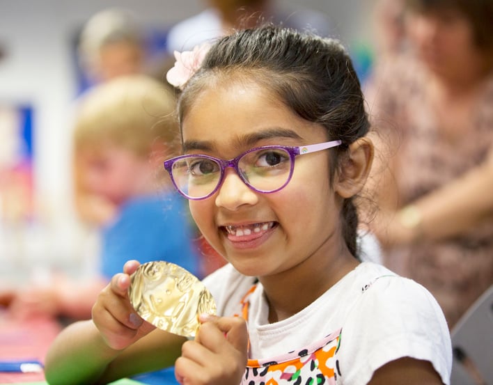 Child with craft activity smiling