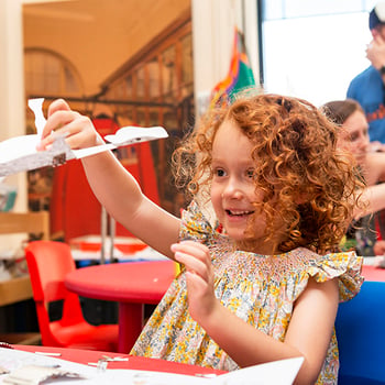 Child smiles while crafting 