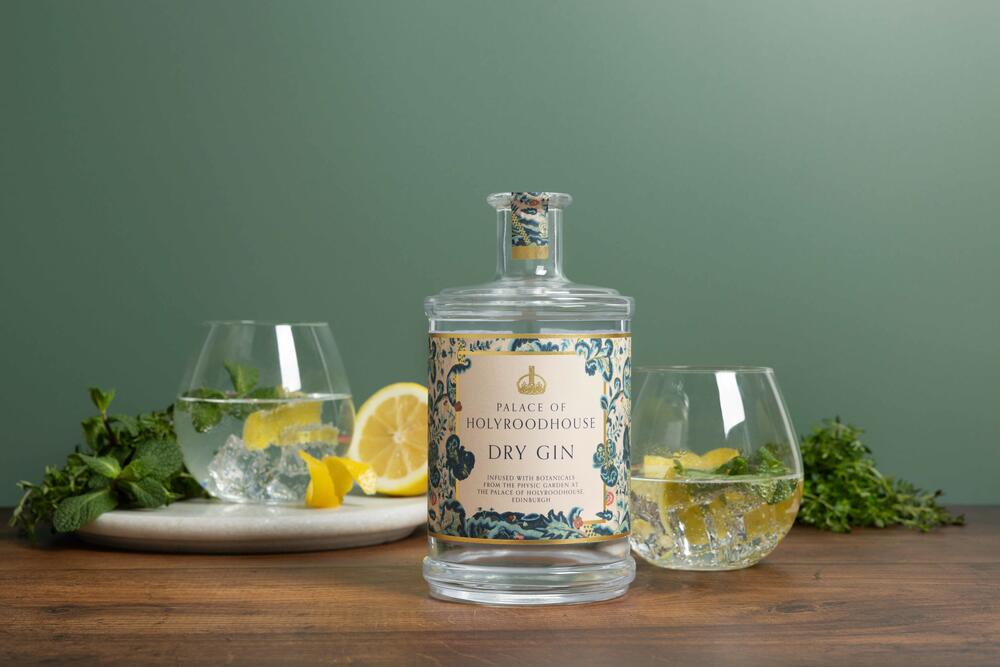 Photograph of a bottle of the Palace of Holyroodhouse Dry Gin surrounded by fresh lemons and herbs