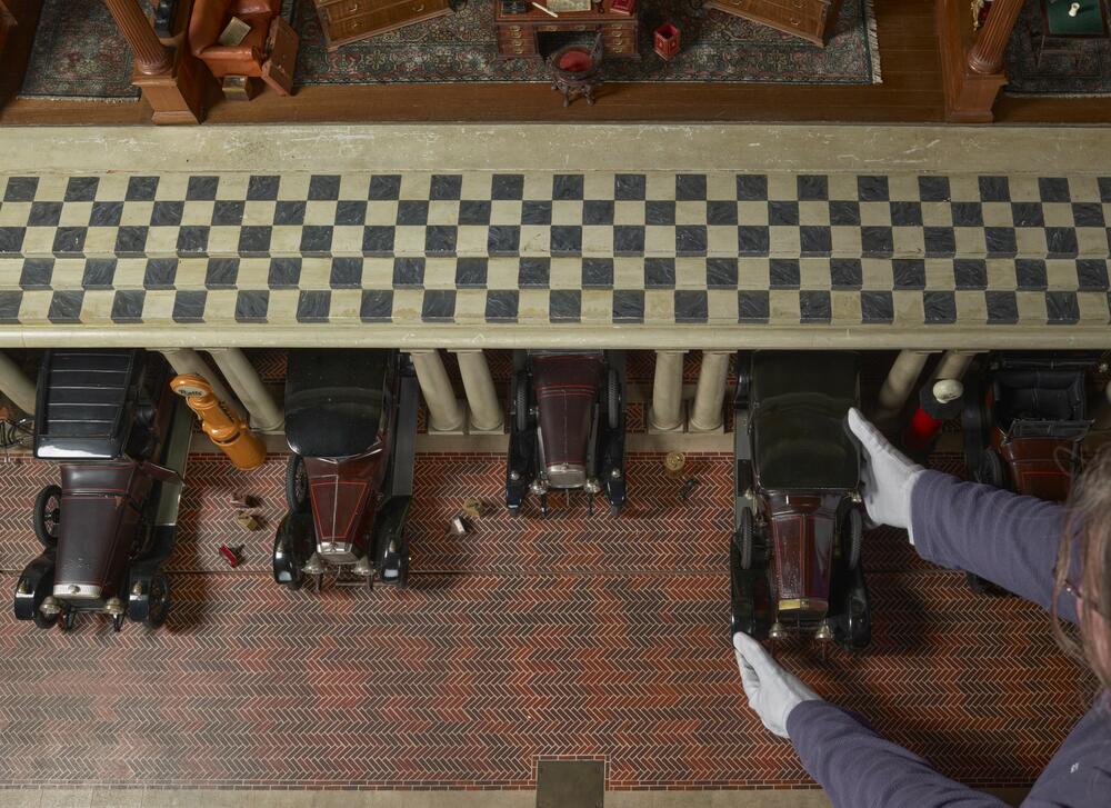 Looking down at the miniature cars in the garage of the Dolls' House