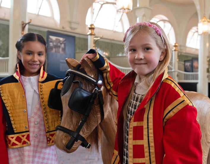 Children tacking up wooden horse